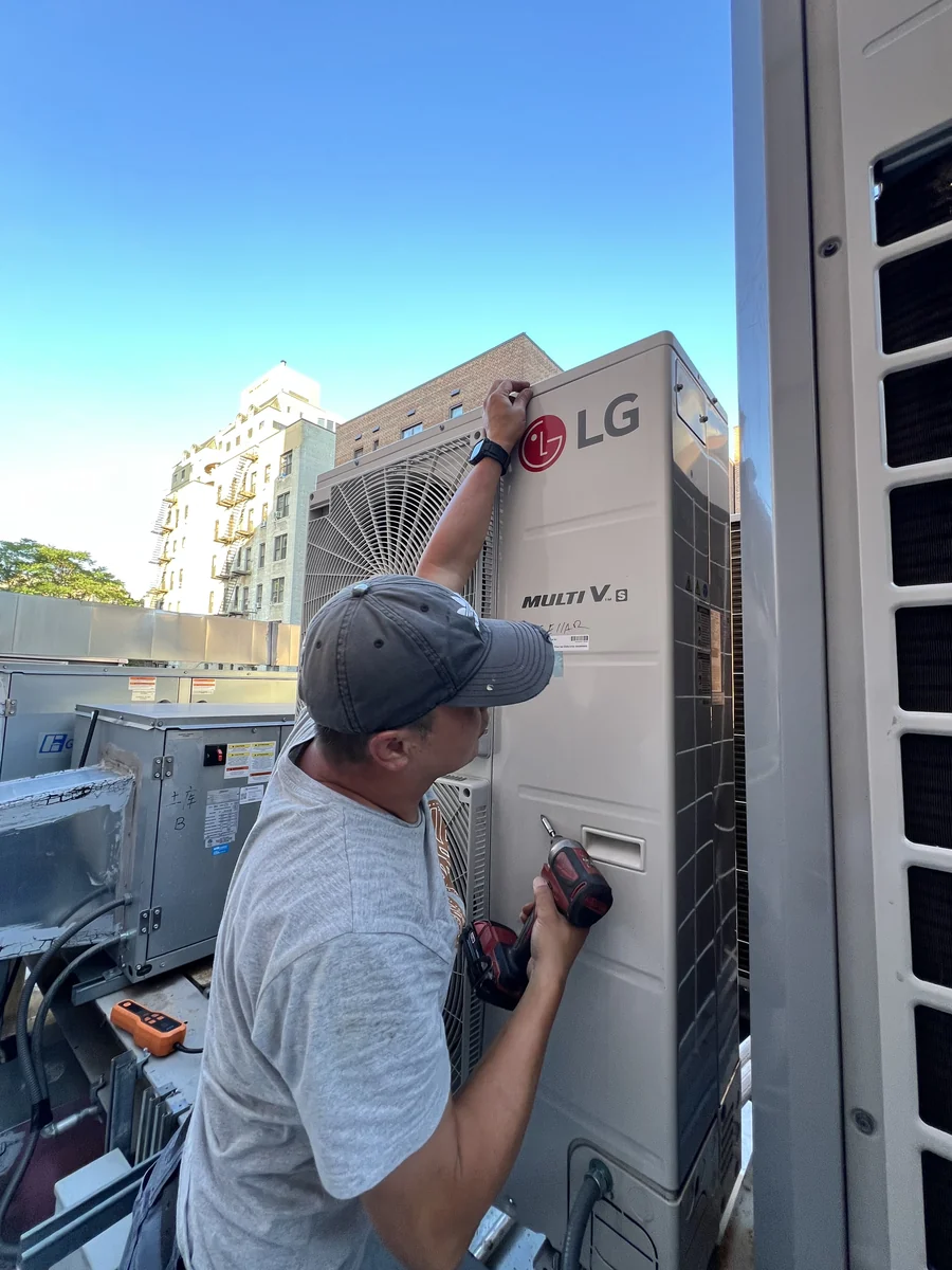 JJR Mechanical technician servicing an LG Multi V VRF outdoor unit on a New York City rooftop