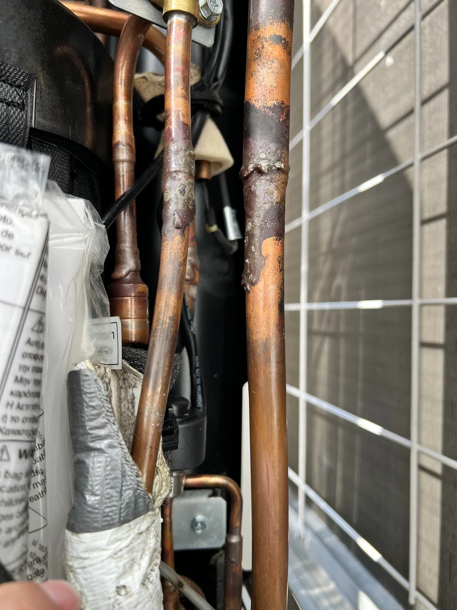 Oxidised and corroded copper refrigerant piping found inside a condensing unit during a service call