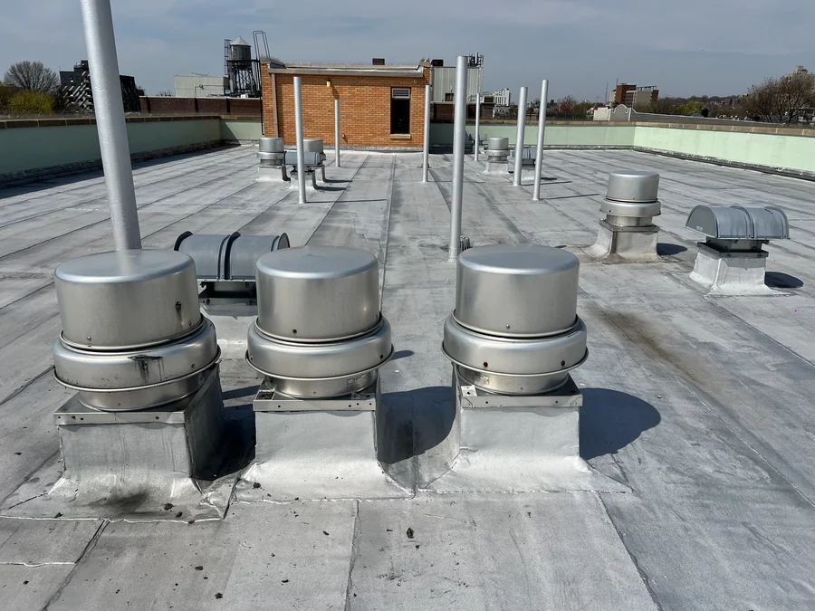 Three downblast roof exhaust fans on a New York City building roof, serviced under a scheduled maintenance program