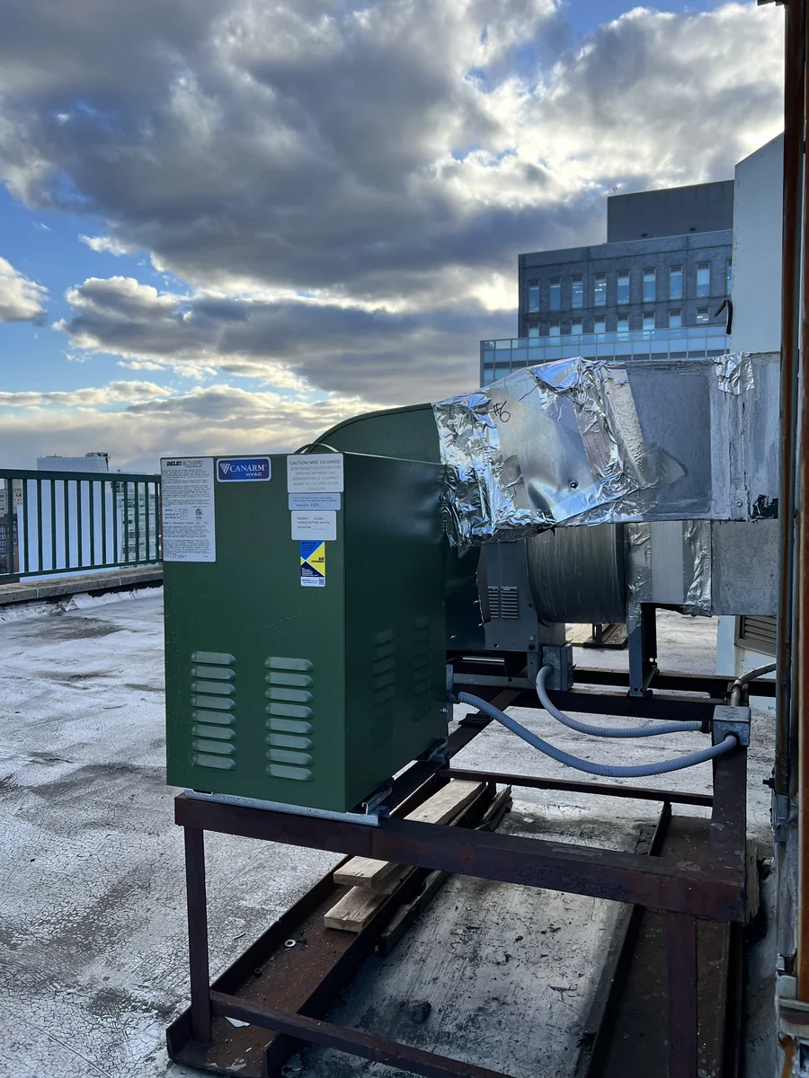 Replacement rooftop exhaust blower set on its steel frame with new insulated ductwork, New York City