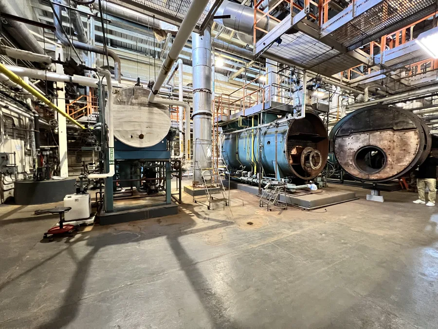 Overview of a NYC commercial boiler plant room with deaerator tank and two firetube boilers